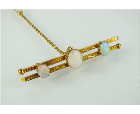 A late 19th century three stone opal bar brooch, designed as a central oval opal cabochon flanked to each side by a smaller o