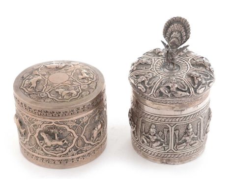 Two Indian white metal covered boxes, both early 20th Century, one with peacock finial and decorated with panels of female de