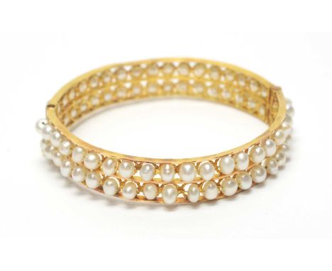 A Victorian-style cultured pearl bangle, set with two rows of cultured pearls, in yellow metal mount with barrel clasp, 6.1cm