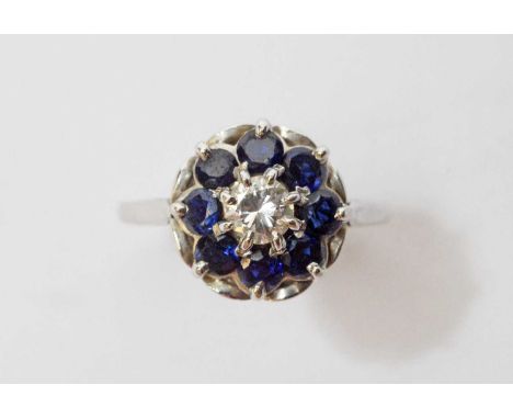 A sapphire and diamond cluster ring, the central brilliant cut diamond weighing approximately 0.35 carats, surrounded by eigh