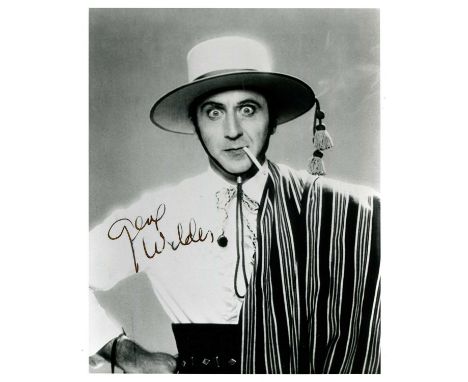WILDER GENE: (1933-2016) American comedy actor. Signed 8 x 10 photograph of Wilder standing in a half-length pose, smoking a 