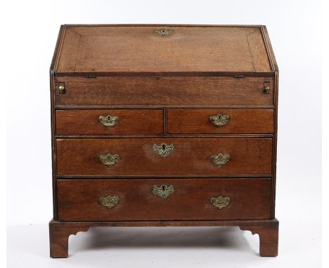 George III oak bureau, the fall opening to reveal a waterfall interior with central well, cupboard and arrangement of drawers