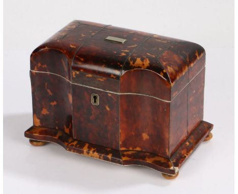 Regency tortoiseshell tea caddy, of casket form, the arched hinged top with a inverted bow to either side of the flat front a