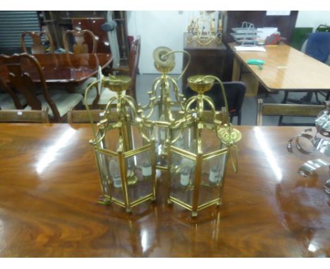 A SET OF THREE BRASS HEXAGONAL LANTERNS,  WITH  PLAIN GLASS PANELS AND THREE  LIGHT INTERIOR, WITH CEILING ROSE (3) 