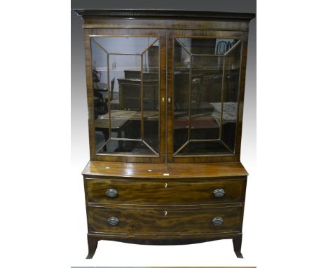 Mahogany bow front bookcase on chest, two astragal glazed doors to the upper section, enclosing adjustable shelves, two deep 