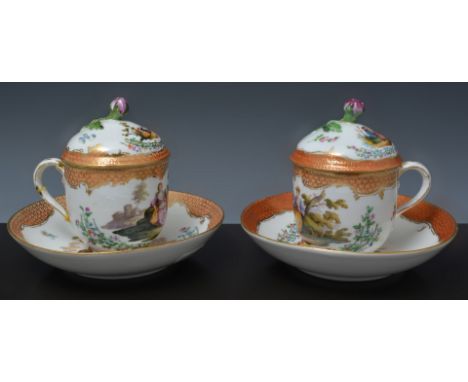 Two Meissen porcelain chocolate cups and saucers, cups with covers, second quality, painted with figurative vignettes, in col