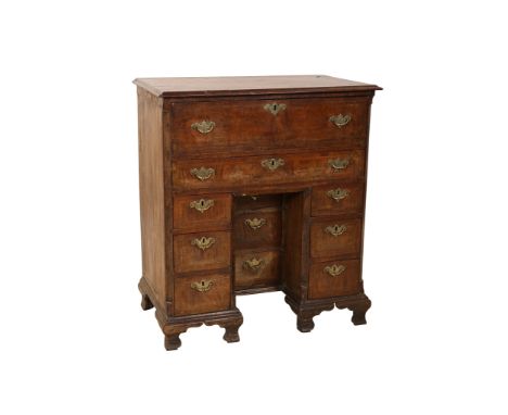 An early 18th Century featherbanded, crossbanded and walnut secretaire kneehole desk, the moulded rectangular top above a sec