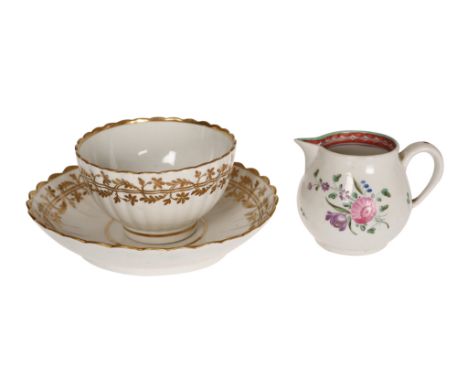 A Caughley tea bowl and saucer, c. 1780-90, each moulded with fluting and gilded with a band of scrolling foliage below a gil