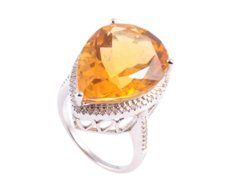 A citrine and diamond ring, the pear cut citrine three claw set within a surround of fifty brilliant cut claw set diamond hig