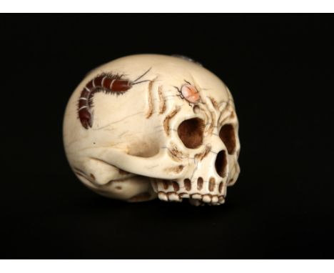 A Japanese ivory Netsuke, Meiji period, carved as a skull and applied in Shibayama style with hardstone and mother-of-pearl t