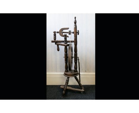 A Rustic Oak Spinning Wheel of traditional form, on tripod legs. Height 40 inches. 