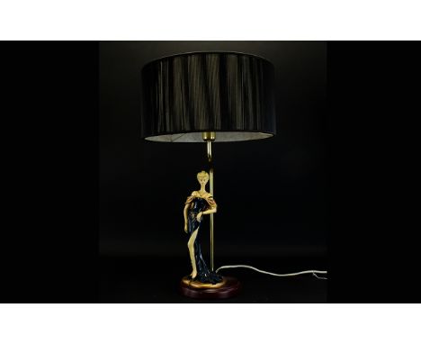 Decorative Table Lamp with a figure of a lady surmounted to a circular mahogany effect base, complete with black shade. 23 in