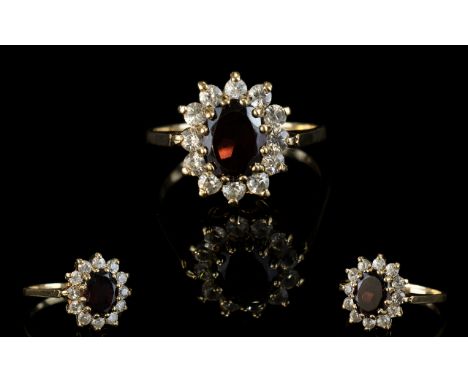 A Vintage 9ct Gold Attractive Garnet And Diamond Set Cluster Ring.  Flower head design. The central Garnet surrounded by 12 D