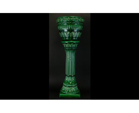 A Floor Standing Ceramic Jardiniere Raised on decorative pillar, the planter decorated in raised foliate repeat design, the w