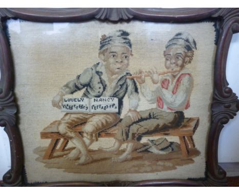 A William IV needlework tapestry depicting two boys seated on a bench, one playing the flute  13'' x 15'' in a glazed, carved