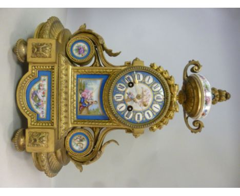 A late 19thC French, decoratively cast gilt metal and painted porcelain cased mantel clock, having an urn finial, foliate scr