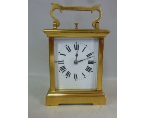 An early 20thC traveller's timepiece, in a lacquered brass case with bevelled glass panels and a folding top handle; the gong