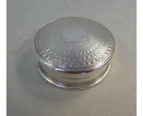 A silver pill box of circular form, having a threaded cap with engine turned decoration  S&M  Birmingham 1924