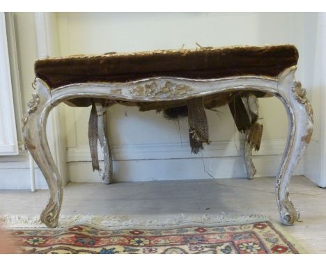 A 19thC Louis XV inspired cream and gold coloured painted framed stool, having a floral tapestry upholstered seat, raised on 