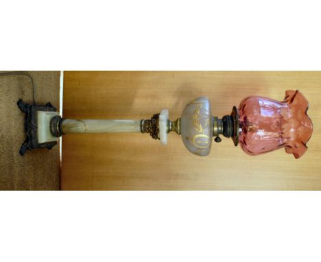 A late 19thC oil lamp (converted to electricity), having an opaque glass reservoir with gilt highlights, on a green onyx colu