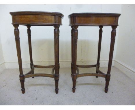 A pair of mid 20thC Louis XVI inspired mahogany lamp tables, each having bowed sides, raised on slender turned, fluted, acant