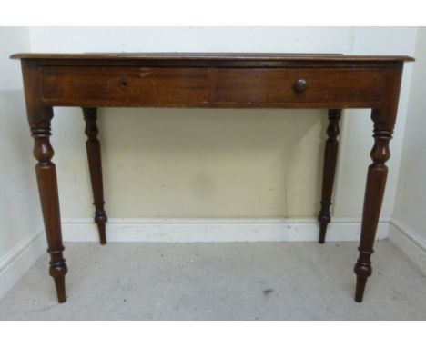 A late Victorian mahogany writing table, having a gilt tool oxblood coloured panelled hide scriber, over two in-line drawers,