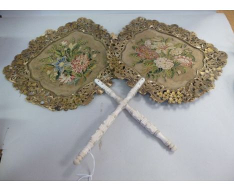 A pair of late 19thC hand-held face screens, each having a floral tapestry panel with a moulded and pierced card border, on c