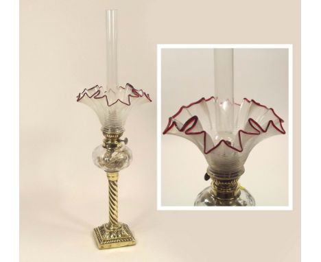 FRENCH OIL LAMP. A 19th century French brass mounted oil lamp, with cranberry-frilled shade. Height 54cm. PLEASE NOTE: Our in