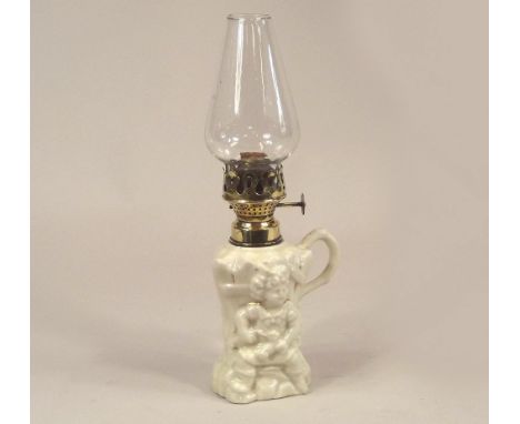 OIL LAMP. A 19th century child-moulded porcelain chamber oil lamp. Height 28cm.