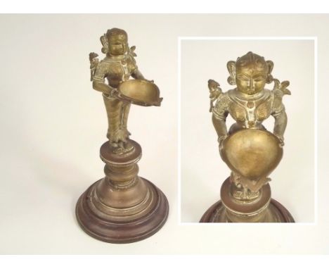 INDIAN OIL LAMP.A 19th century, cast brass Indian oil lamp in the form of the Hindu goddess Lakshmi. Height 30cm.