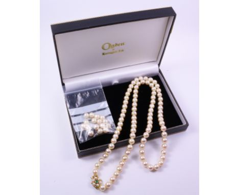 Single row cultured pearl necklace, the stones of approx 6mm dia., emerald set clasp stamped 375 (with original Ogdens of Har