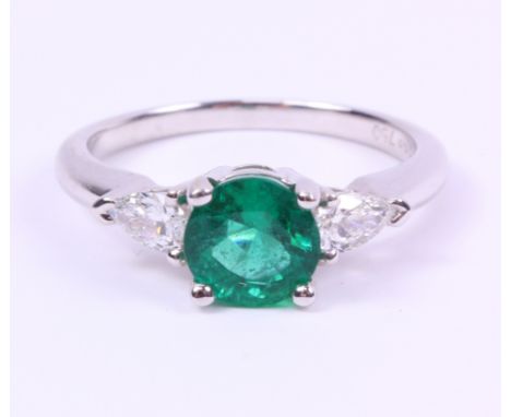 White gold ring set with a round cut emerald of approx 1.13 carats and a pear shaped diamond to each shoulder hallmarked 18ct