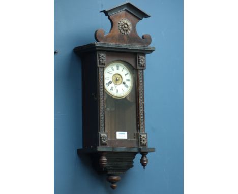 Late 19th century musical wall clock, stained architectural case with circular dial, twin train movement playing a tune on th
