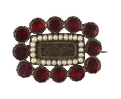 A Georgian flat-top garnet pearl and hairwork mourning brooch, circa 1820, central woven hair panel beneath bevelled glass wi