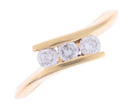 An 18ct gold three stone diamond cross-over ring, channel set with modern round brilliant-cut diamonds, total diamond content