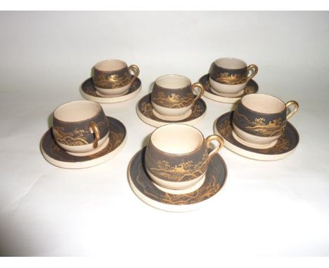 A set of six late 19th century Satsuma cups and saucers with gilded landscape decoration on a black and cream ground, with pa
