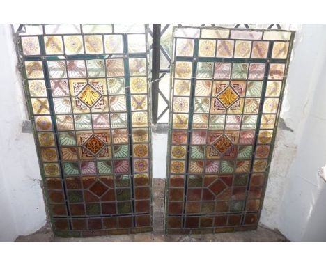 A near pair of late 19th/early 20th century leaded light panels of rectangular form decorated with a stylised foliate border 