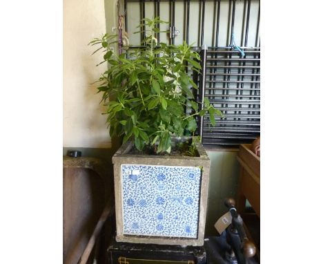 An unusual four sided planter composed of four oriental blue and white ceramic tiles with trailing floral decoration, each ti