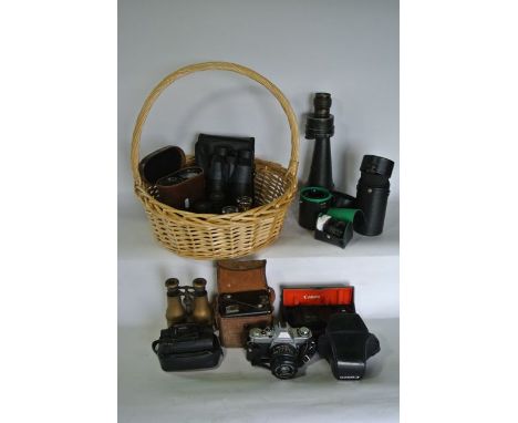 A wicker basket containing a large 20th century monocular, various other vintage binoculars together with a selection of vint