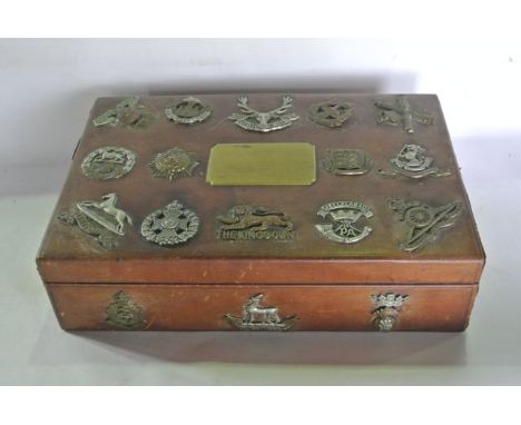 A tan leather clad chest of shallow rectangular form with central brass plaque to top reading - Fourth Division 1917, decorat