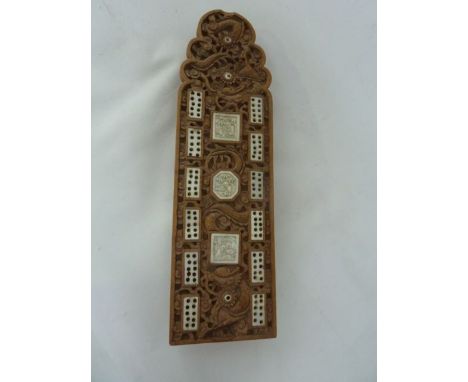 A 19th century sandalwood cribbage board with carved dragon, pearl and cloud detail inlaid with ivory markers and pins