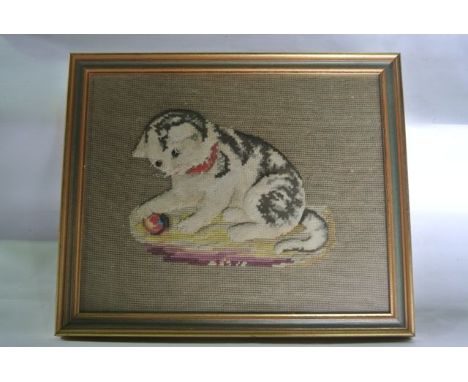 A 19th century embroidered study of a tabby kitten seated upon a multi-coloured rug playing with a ball of wool, with applied