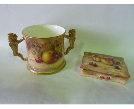 A loving cup in the Royal Worcester manner with gilded lion handles and finely painted decoration incorporating various fruit