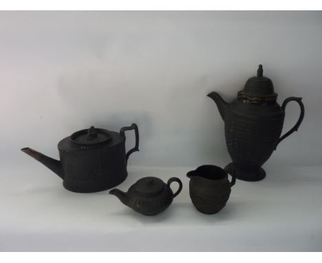 A collection of 19th century and other black basalt wares including a coffee pot with ridged moulding and figural knop, a tea