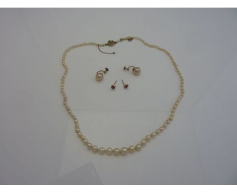 A graduated strand of pearls, the unmarked gold flower head clasp inset with pearls; a pair of pearl earrings, measuring 8.8m