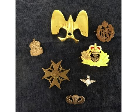 A collection of military badges including WWII German, Parachute sterling silver badge, ARP, RAF etc also a trench art eagle 