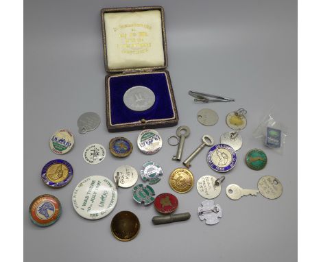 A collection of badges, including enamel and a commemorative token 
