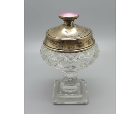 A silver topped dressing table pot with cut glass base, guilloche enamel top and mirror under the lid, London 1927 