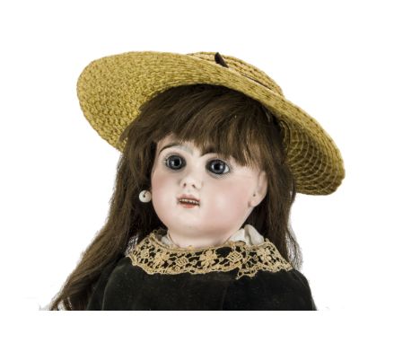 A Tete Jumeau Bébé, with fixed blue glass eyes, open mouth with teeth, dark brows, pierced ears, brown hair wig on cork pate,