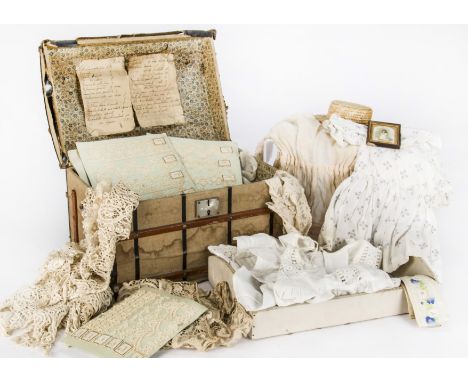 A doll’s trunk, canvas covered with oil-cloth and wood banding, metal carry handles, a handwritten Italian list pasted to the